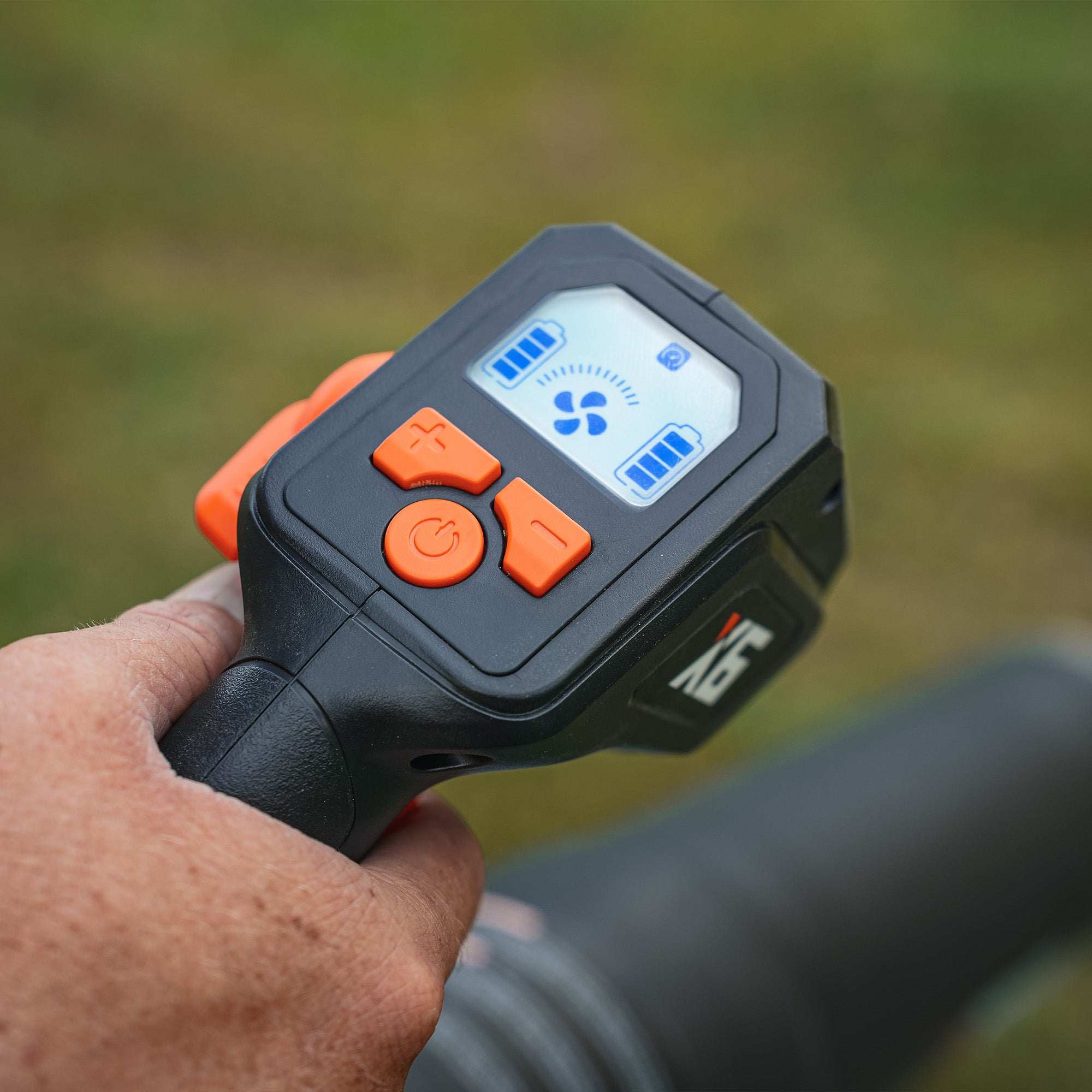 Close-up of X6 60V Max cordless backpack blower handle with LCD display and orange control buttons showing battery and fan settings.